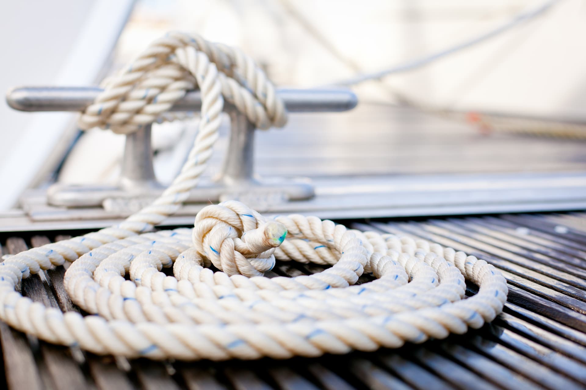 Neatly coiled mooring rope tied off on a teak deck